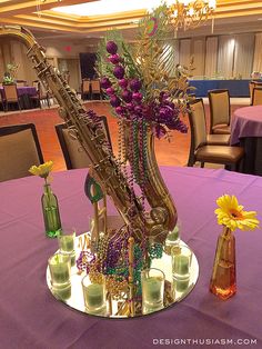 a vase filled with flowers sitting on top of a table next to a saxophone instrument