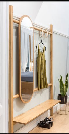 a wooden bench sitting under a mirror next to a plant