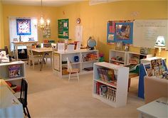 a classroom with desks, chairs and bookshelves filled with children's books