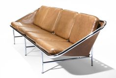 a brown leather couch sitting on top of a metal frame