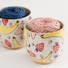 two bowls with yarn in them sitting next to each other