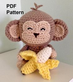 a crocheted monkey holding a banana on top of a white table with text overlay