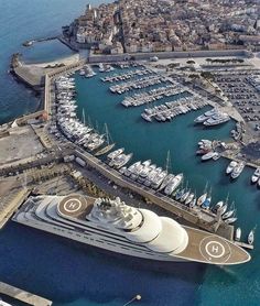 an aerial view of a large cruise ship docked at a harbor with many boats in the water