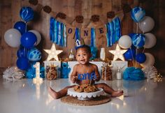 a baby sitting in front of a cake