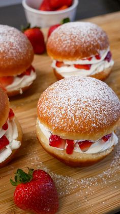 strawberry short sandwiches on a cutting board with powdered sugar and strawberries