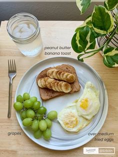 a white plate topped with eggs, bread and grapes