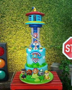 a birthday cake sitting on top of a table next to a traffic light and stop sign