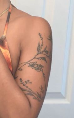 a woman with tattoos on her arm and shoulder