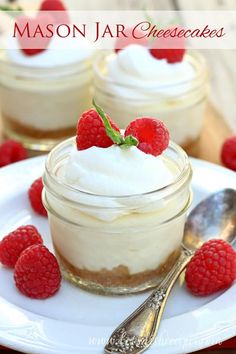 raspberry cheesecake in a jar on a white plate with spoons next to it