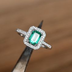 This is a lab emerald ring. The main stone is about 5mm*7mm emerald cut, weight about 0.85 carats. The basic metal is sterling silver and plated with rhodium. To change the metal to a solid gold (white/rose) or platinum is also available, please ask for a quotation if you want. You can also go to my shop Home for more elegant rings: https://www.etsy.com/shop/godjewelry?ref=hdr_shop_menu Emerald is May birthstone. More emerald rings: https://www.etsy.com/shop/godjewelry?ref=hdr_shop_menu&sect Vintage Emerald Engagement Ring, Birthstone Promise Rings, Elegant Rings, Smaragd Ring, May Birthstone Rings, Emerald Rings, London Blue Topaz Ring, Promise Rings For Her, Sterling Silver Engagement Rings