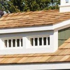 the roof of a white house with brown shingles