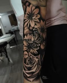 a woman's arm with flowers and a butterfly on the left side of her arm