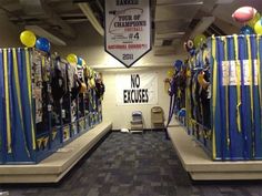 an office hallway decorated with blue and yellow striped curtains, balloons, and signs that say no excess