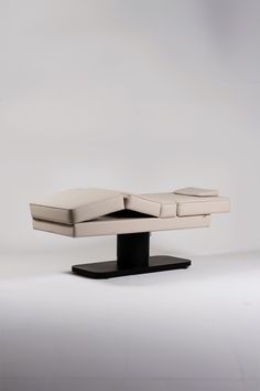 a white couch sitting on top of a black stand