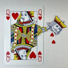 a playing card with the queen of spades on it and two hands holding cards