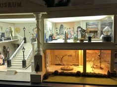 the inside of a doll house with many items in it's display case and stairs leading up to the second floor