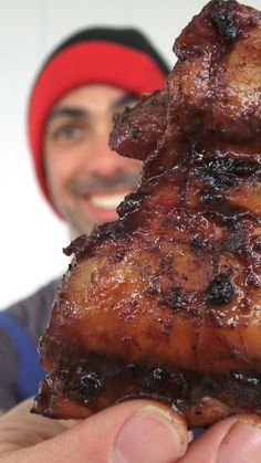 a man holding up a piece of meat in his hand