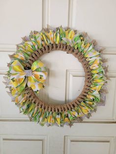 a wreath with yellow and green flowers hanging on the front door, decorated with burlap