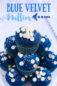 blue velvet muffins with white sprinkles are stacked on top of each other