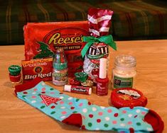 an assortment of candy and candies sitting on a table next to a christmas stocking