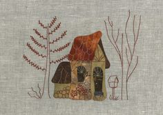 a small house with trees and bushes in the background is embroidered on linen, which has been stitched onto it