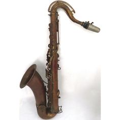 an old saxophone sits upright on a white background