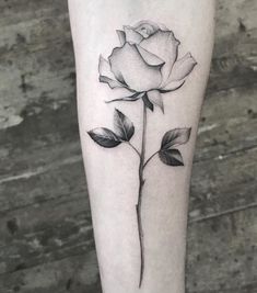 a black and white rose tattoo on the leg