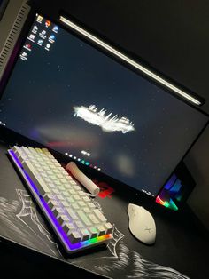 a computer monitor with a keyboard and mouse on the desk next to it is lit up