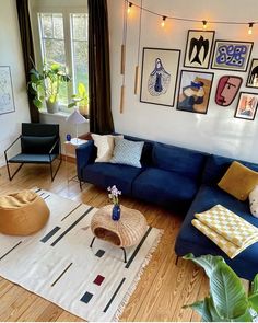 a living room with blue couches and pictures on the wall above it's coffee table