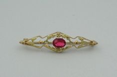 "Vintage 10K two color gold broach/pin set with a 1 carat oval created ruby. Beautifully balanced with flowers and petals, the two colors of gold bring a warmth to the deep red of the ruby. There is a very small chip near the girdle of the ruby but hard to see without magnification. This is a wonderful example of art in jewelry. FREE SHIPPING! Details: 10K Two Color Gold (shown in picture) Created Ruby: (1) 5 mm x 7 mm oval Stone Color: Ruby Red Approximate Stone Weight: 1 ct. Approximate Dimens Oval Yellow Gold Brooches With Gemstone, Oval Brooch In Fine Jewelry Style For Formal Occasions, Yellow Gold Oval Brooch For Wedding, Oval Gemstone Brooches For Weddings, Oval Gemstone Brooches For Anniversary, Ornate Oval Brooches For Anniversary, Ornate Oval Anniversary Brooches, Formal Ruby Brooch Jewelry, Vintage Jewelry Box