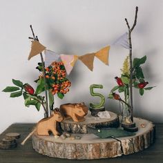 a wooden table topped with vases filled with flowers and animals on top of it