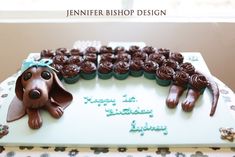 a birthday cake decorated with chocolate cupcakes and a dachshund