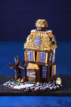 a gingerbread house with decorations on the roof and windows is shown in front of a blue background