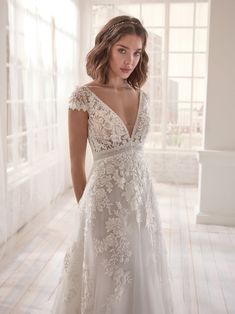 a woman in a wedding dress standing on a wooden floor