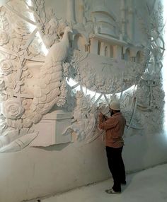 a man standing next to a white sculpture