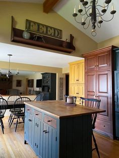 a kitchen with an island and chairs in the center, next to a dining room table