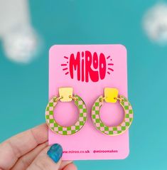 Acrylic, earrings in circle shape with pink and green checkerboard pattern on front facing side.   Made from laser cut acrylic, with printed design.   The acrylic is mirrored gold.   Earring posts are made from surgical steel with butterfly fastening. Jump rings are gold plated on a base metal.    Comes on a backing card & wrapped in colour tissue paper. Measures- 3.8cm wide. Total drop 4.1cm Acrylic Earrings Laser Cut, Earrings Acrylic, Backing Card, Checkerboard Pattern, Laser Cut Acrylic, Earring Posts, Gold Earring, Green Earrings, Earring Patterns