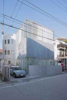 a car parked in front of a building on the side of a road with power lines above it