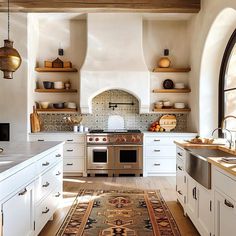 a kitchen with white cabinets and an area rug