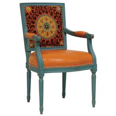 an orange and blue upholstered chair with a medallion on it's back