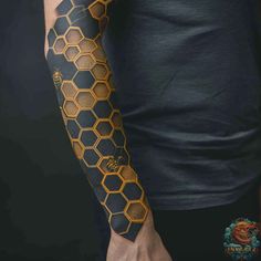 a man's arm with honeycombs on it