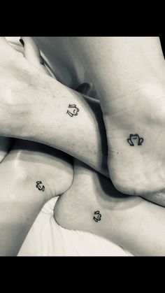 three people with tattoos on their feet laying down together in the middle of a circle