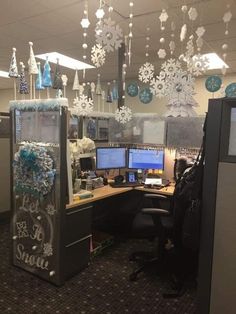 an office cubicle decorated for christmas with snowflakes hanging from the ceiling and decorations