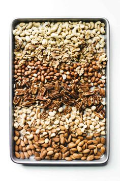 nuts and seeds in a metal tray on a white background, top view stock photo