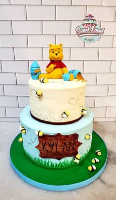 a winnie the pooh birthday cake is decorated with fondant and honeybees