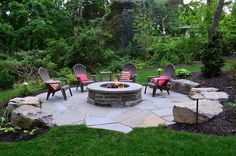 an outdoor fire pit surrounded by chairs