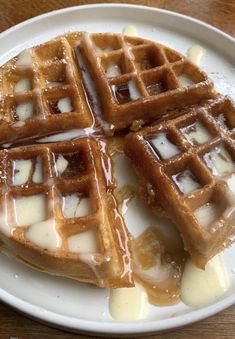 waffles on a plate with syrup and butter drizzled over them