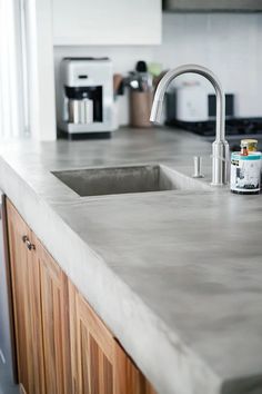 a kitchen counter top with a sink and microwave in the backgroung area