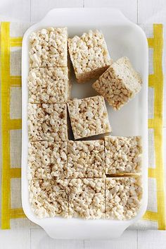 rice krispy treats on a plate with a yellow and white towel in the background