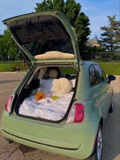 a small car with its trunk open on the street